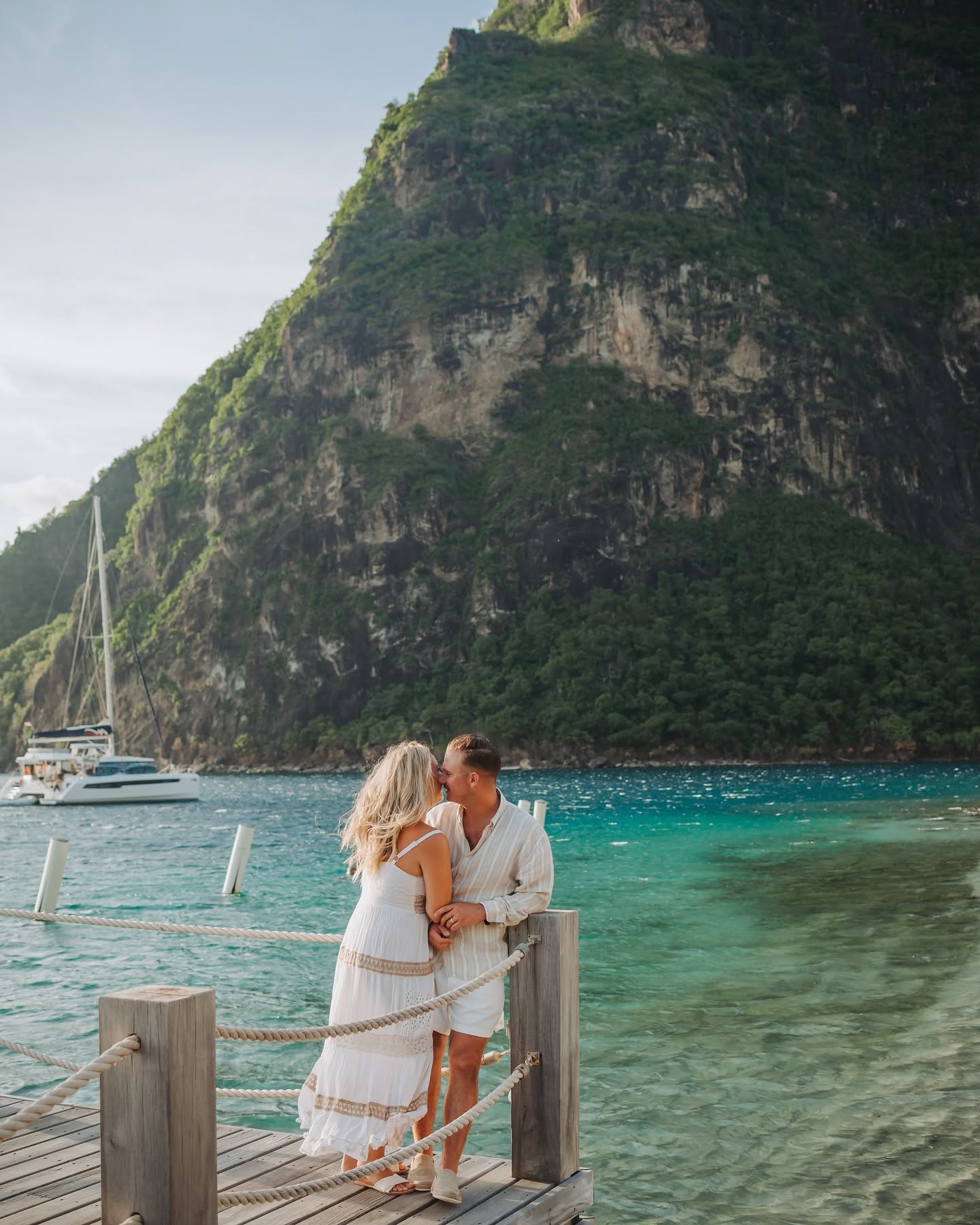 A kiss on the dock at Sugar Beach with a catamaran anchored behind